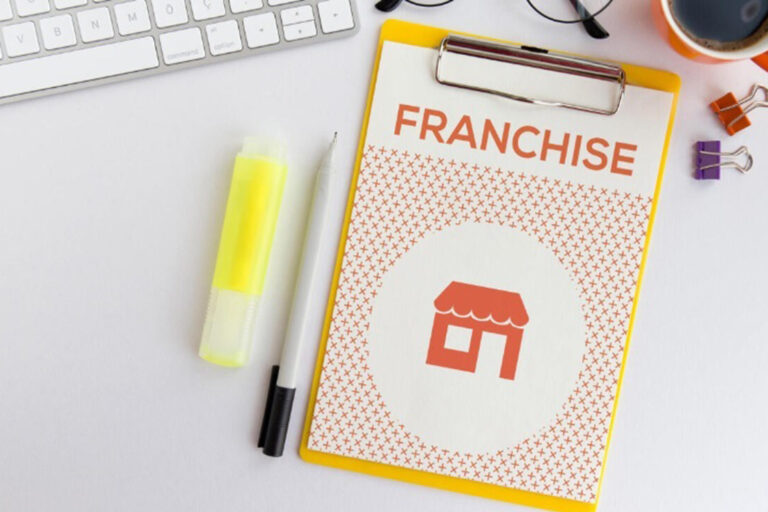 Clipboard with 'FRANCHISE' text and office supplies on a desk.